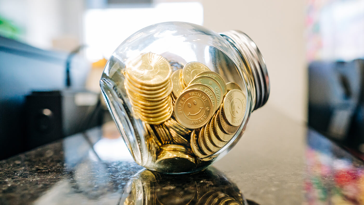 Gold coins in a clear bank.