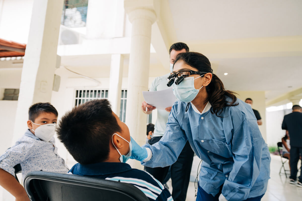 A CDP dentist checks a pediatric patient while participating in CDP's dental volunteer program.