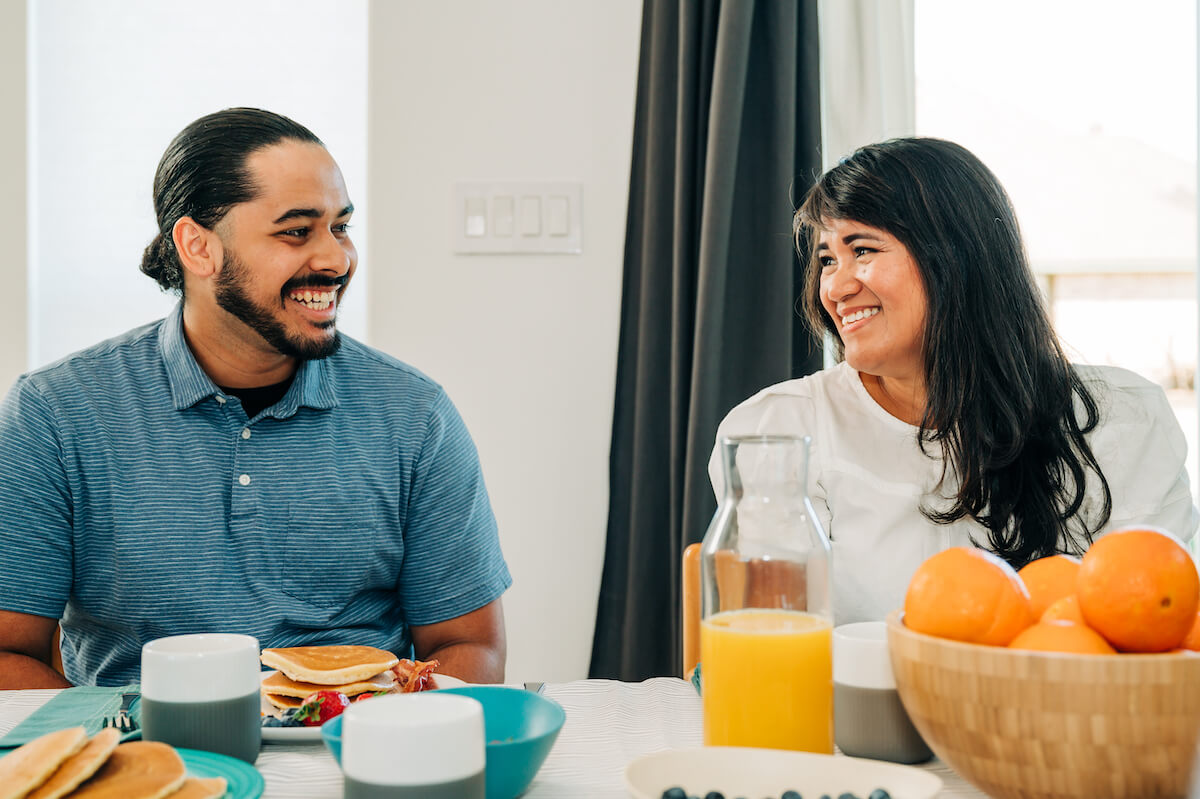 A CDP dentist and his wife sit at the breakfast table, enjoying some quality family time together in their home.