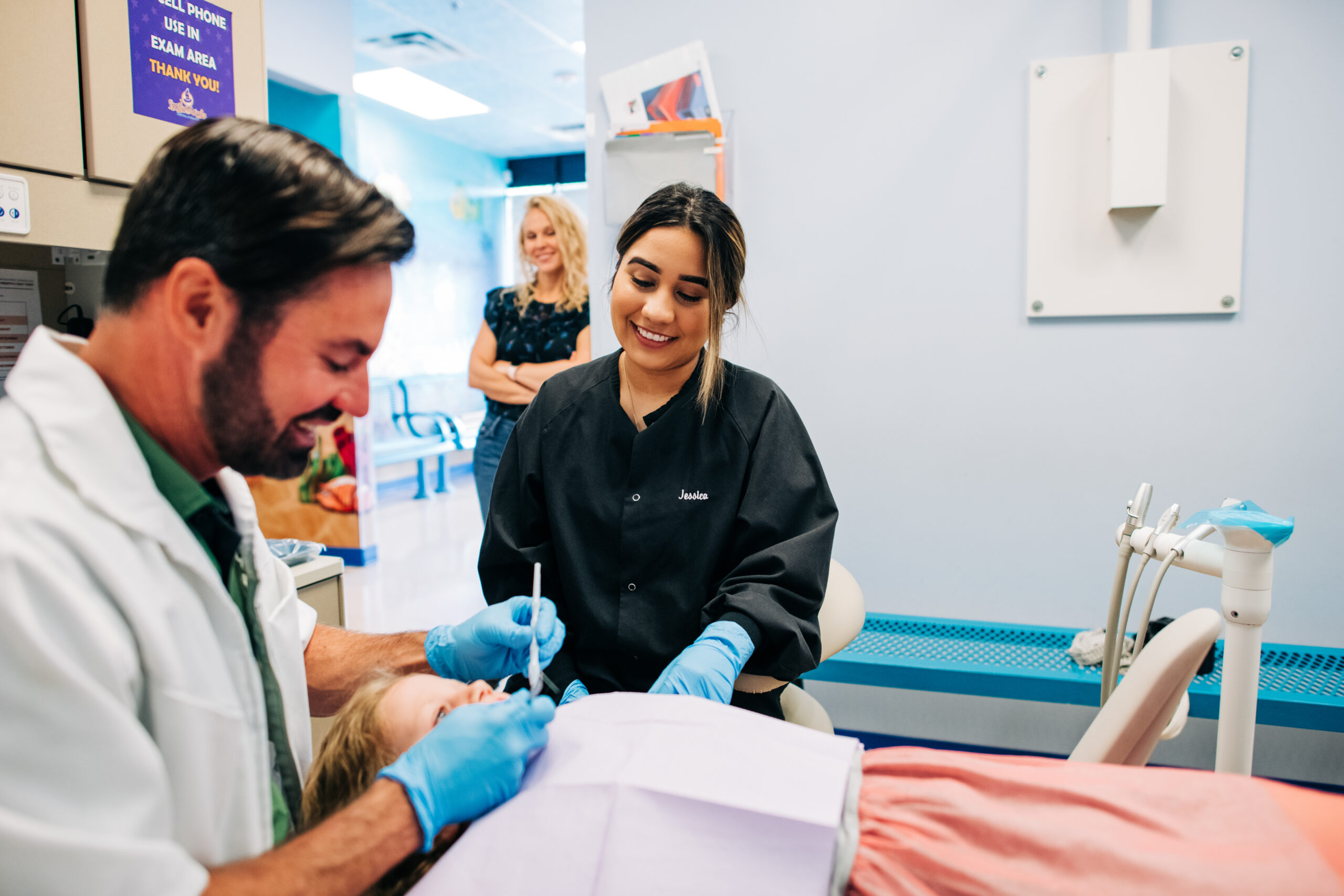 CDP dentist cleaning child's teeth white mom and hygienist watch. The skills needed to be a dentist vary. While you must know how to fix broken teeth, for example, you must also work on key “soft skills.”