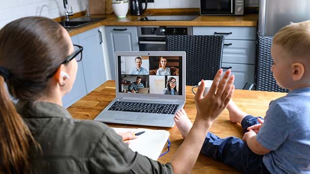 Remote working female on a conference call with her son by her side.