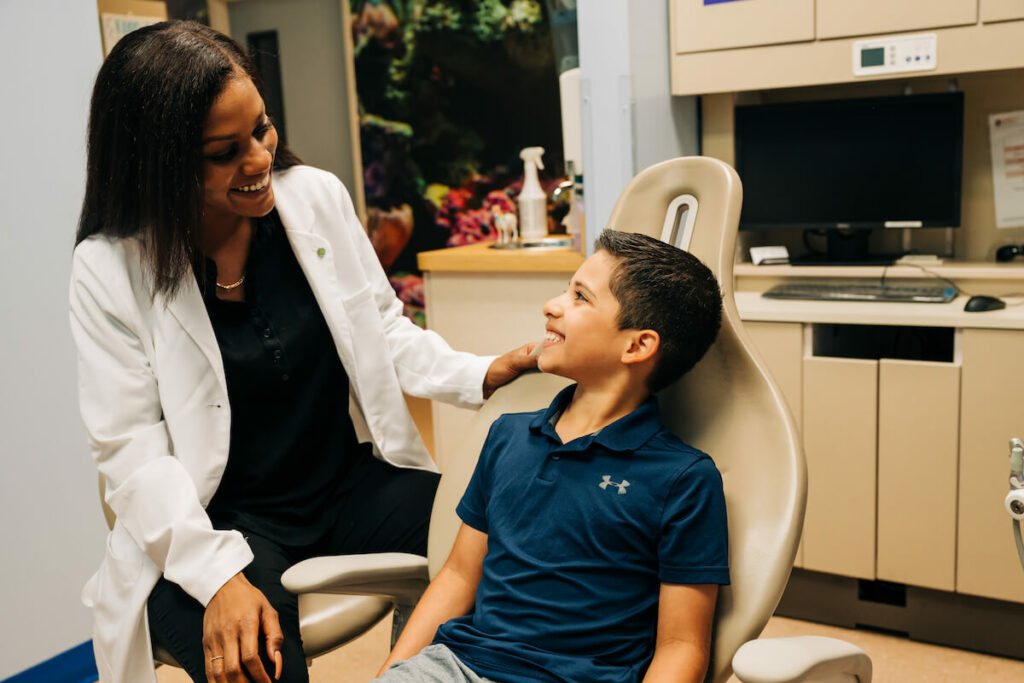 Female CDP dentist comforting young male chairside