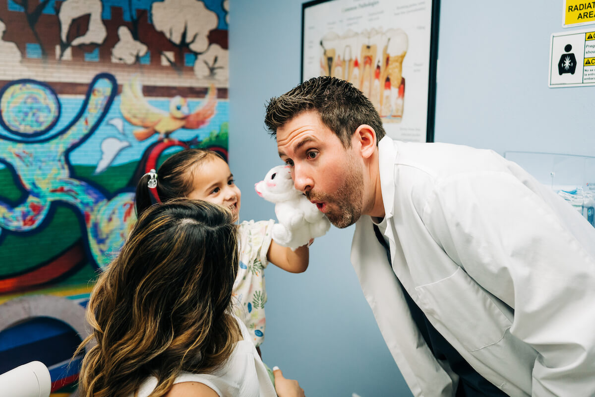 A CDP pediatric dentist goofing around with two child patients.
