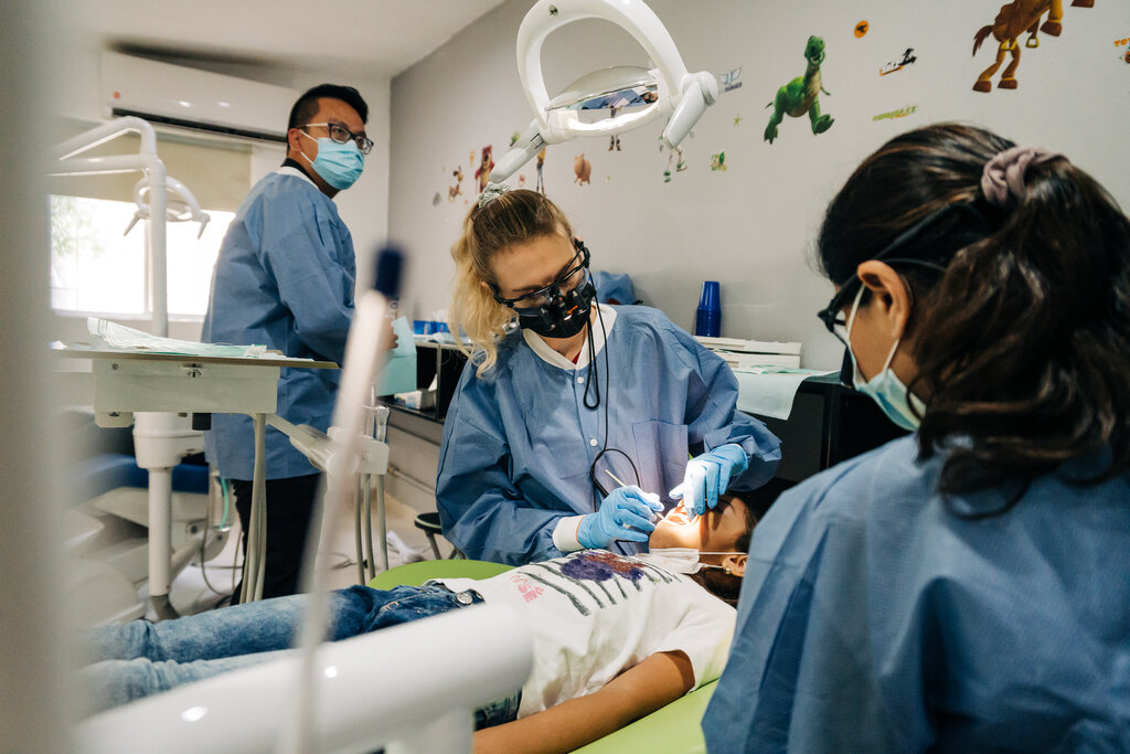 Three CDP dentists working on young patient in Mexico. With dental mentorship, team building, and humanitarian outreach, we ensure you'll put your best foot forward.