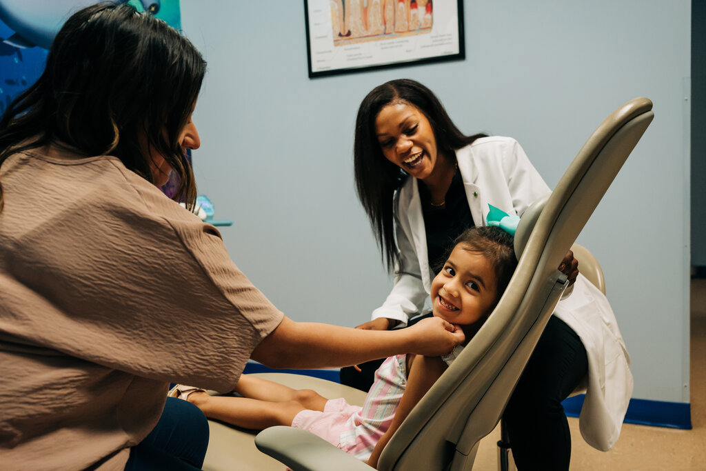 Smiling patient, smiling dental team and family.