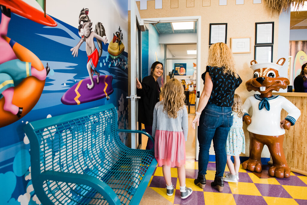 Hygienist welcomes family back to the dental exam room.