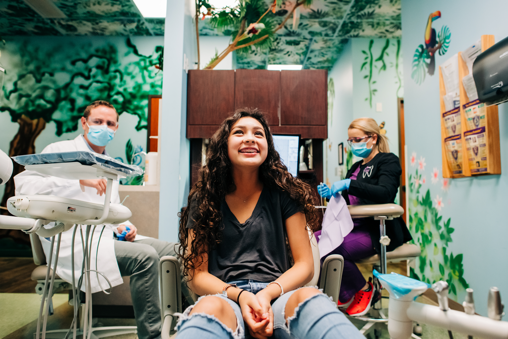 Smiling ortho patient in dental chair.