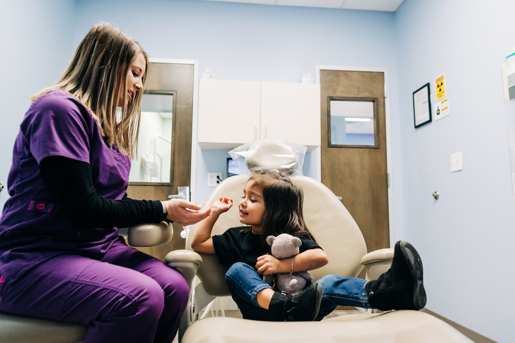 Hygienist creating a bond with young female patient. 