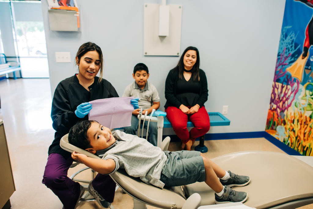 Hygienist prepping a young patient in the dental chair.