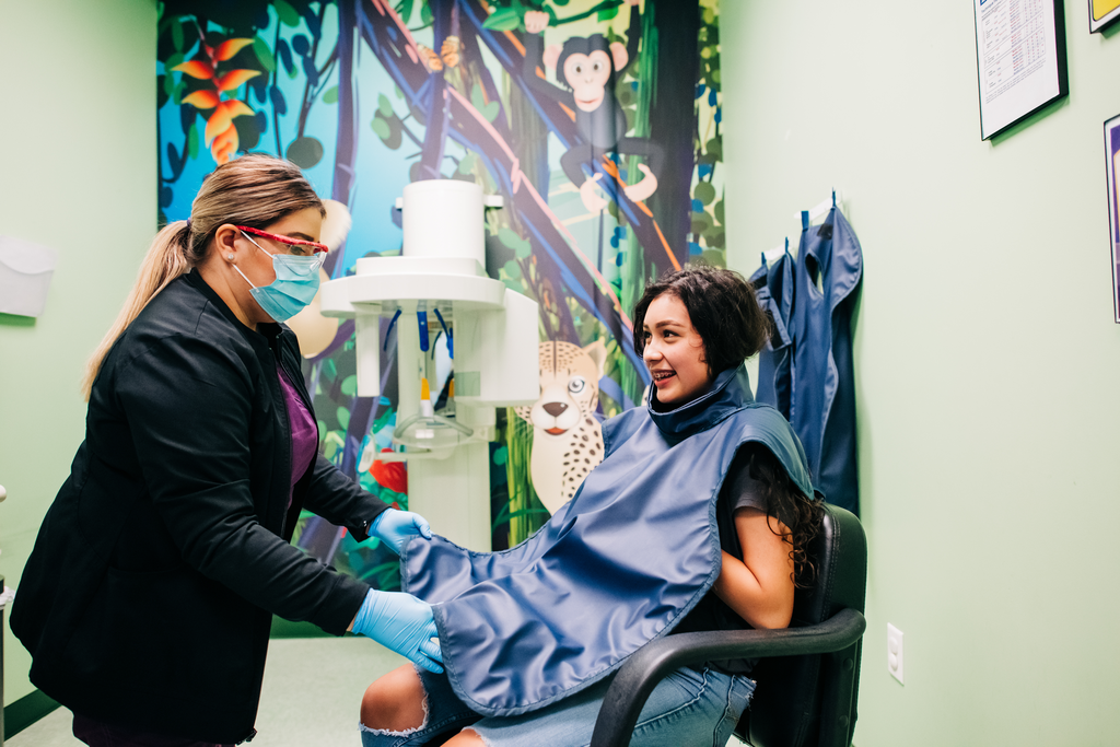 Hygienist prepping a teen patient for X-Rays.