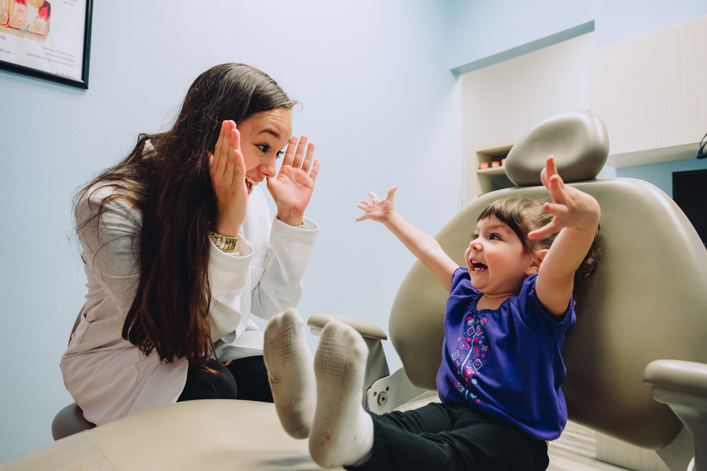 Female dentist playing peek-a-boo with small child. Dentists established, own, and operate Community Dental Partners, while chains are primarily managed by investors and administrators.