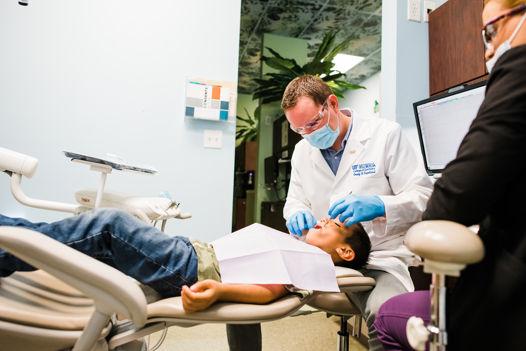 Part-time dentist working on young patient.
